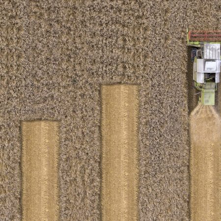 Combine harvester in a field used to illustrate a chart by showing four rows of varying links