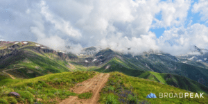 dirt path fading over a mountain with clouds
