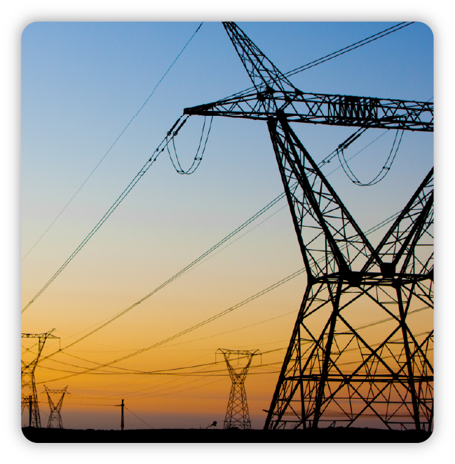 Electrical towers set against blue and gold sky