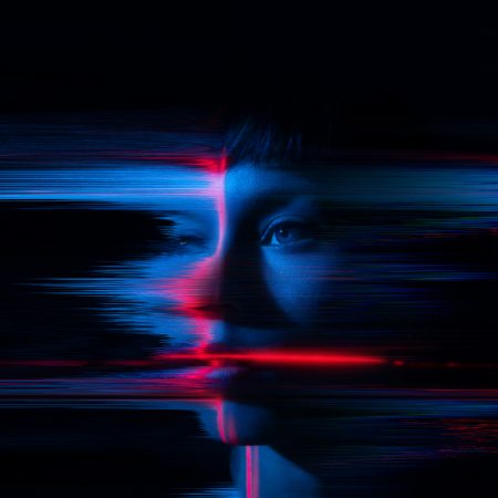A young woman appears to glitch and fragment, symbolizing the merging of humanity with the digital world. A visual representation of contemporary themes such as AI, the metaverse and cyber culture