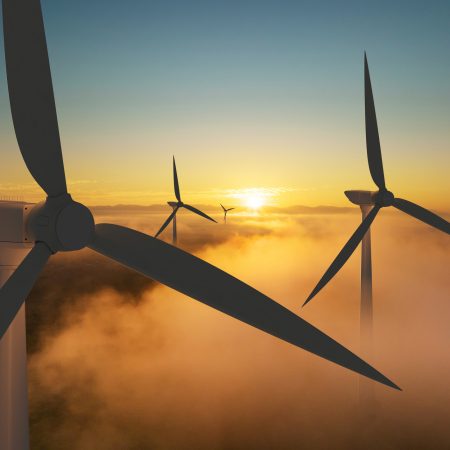 Wind turbine silhouette at sunrise, wind energy and nature concept.